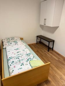 a bed in a room with a cabinet and a table at Das Rosenhaus in Hargesheim in Hargesheim