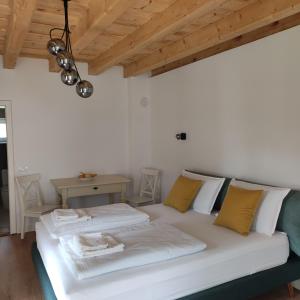 a white bed in a room with a wooden ceiling at Casa Via Viscri in Buneşti