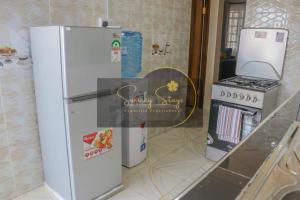 a white refrigerator and a stove in a kitchen at Swanky Stays I in Nairobi