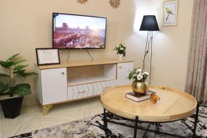 a living room with a flat screen tv on a white cabinet at Swanky Stays I in Nairobi