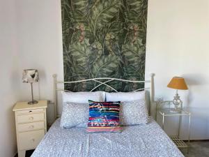 Un dormitorio con una cama con papel pintado tropical. en Your House in Menorca, en Ciutadella 41 fotos más