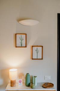 una mesa con una lámpara y dos cuadros en la pared en Forte 51, en Forte dei Marmi