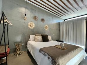 Un dormitorio con una cama grande y una pared en L'École Eco Resort, 