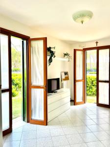 a living room with a tv on a dresser at Beachside Family Garden Retreat in Cavallino-Treporti