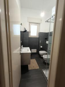 a bathroom with two toilets and a sink at La terrazza sul mare - Marina di Novaglie in Alessano +27 photos