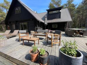 a deck with benches and tables and a house at Wild Beach Spa in Kihelkonna