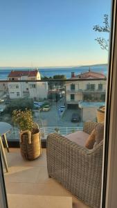 a balcony with wicker chairs and a view of the ocean at Apartments iris in Brela