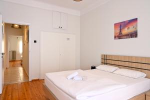 Ein weißes Bett in einem weißen Zimmer mit in der Unterkunft Thessaloniki Center Aristotelous Apartment in Thessaloniki