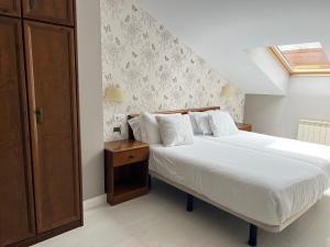 een slaapkamer met een bed en een houten kast bij Apartamentos Las Vegas in Ribadesella