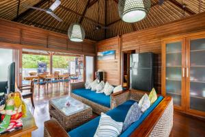 a living room with a blue couch and a table at Gecko Villa & Bungalows in Nusa Lembongan