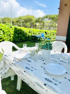 a table with plates and glasses and a plant on it at Beachside Family Garden Retreat in Cavallino-Treporti