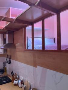 a kitchen with a window above a counter with a bed at Hidden Heaven in village Krini in Kríni