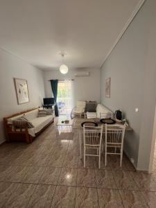 a living room with a couch and a table at Alexandra’s apartment in Paralía Akrátas