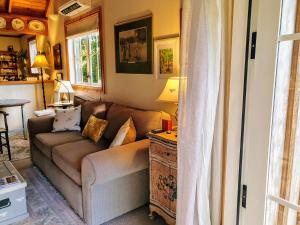 ein Wohnzimmer mit einem Sofa und einem Tisch in der Unterkunft Bumblebee Cottage in Greytown