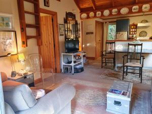 a living room with a couch and a table at Bumblebee Cottage in Greytown