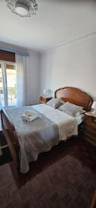 1 dormitorio con 1 cama grande y cabecero de madera en Casa da Praia en Póvoa de Varzim