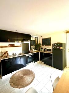 a kitchen with black cabinets and a black refrigerator at La Hiboutière in Saint-Laurent-du-Var