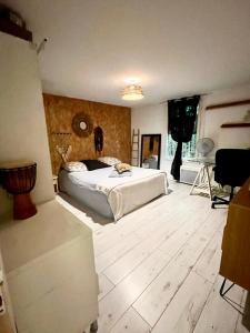 a bedroom with a bed and a wooden floor at La Hiboutière in Saint-Laurent-du-Var