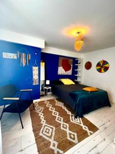 1 dormitorio con paredes azules, 1 cama y escritorio en La Hiboutière, en Saint-Laurent-du-Var