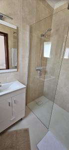 een badkamer met een douche en een wastafel bij Casa da Praia in Póvoa de Varzim