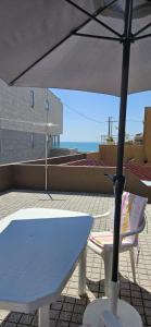 een witte tafel en een paraplu op een dak bij Casa da Praia in Póvoa de Varzim