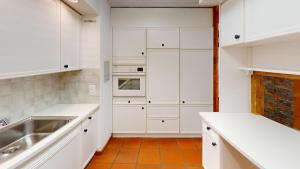 - une cuisine blanche avec des placards blancs et un évier dans l'établissement Zentrale 5,5 Zimmer Wohnung für bis zu 8 Personen, à Coire