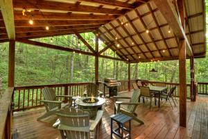 a screened porch with tables and chairs on a wooden deck at K6 Lodge Gather around the firepit soak in the hot tub and splash in the creek in Blue Ridge