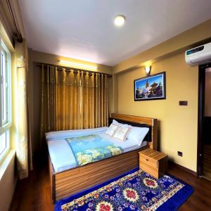 een slaapkamer met een bed met een blauw tapijt bij House of Forrest in Kathmandu