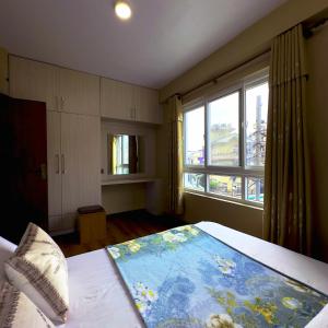 een slaapkamer met een bed en een groot raam bij House of Forrest in Kathmandu