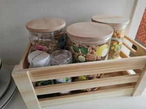 a wooden shelf with four jars filled with food at Tui Nest Garden Unit in Silverdale