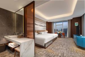 JiangshanにあるJiangshan Haiwaihai Grand Hotelのベッドと鏡のあるホテルの部屋