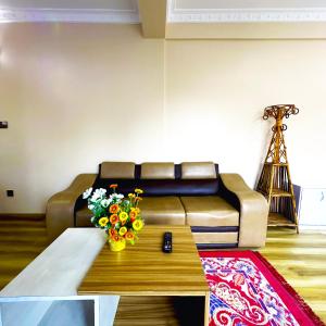 ein Wohnzimmer mit einem Sofa und einem Tisch mit Blumen in der Unterkunft House of Forrest in Kathmandu