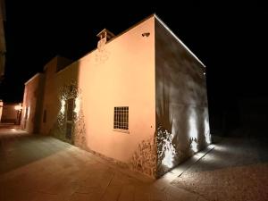 Antica Dimora "Lu suli, Lu mari, Lu jentu" في Monacizzo: مبنى أبيض في الليل مع أضواء عليه