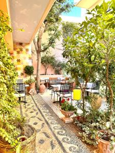 un patio con sillas, mesas y árboles en Rozmari and Spa en Agia Galini