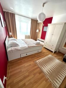 1 dormitorio con cama blanca y pared roja en Le Petit Paris- Central , Dorobanți with a view, en Bucarest