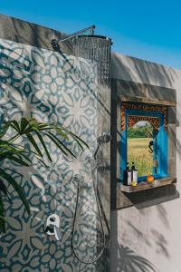 a bathroom with a shower with a mirror at Suga Estate - Rice Field View Villas in Ubud