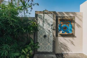 a door with a blue and white tile on a wall at Suga Estate - Rice Field View Villas in Ubud
