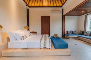 a bedroom with a bed with a teddy bear sitting on it at Suga Estate - Rice Field View Villas in Ubud
