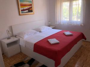 1 dormitorio con 1 cama con 2 toallas en Apartment Frane Podstrana with private pool, en Podstrana