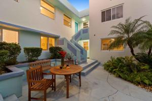 - un patio avec une table et deux chaises et un bâtiment dans l'établissement Condo by the Beach King Bed Lush Patio w BBQ Breakers Key Seven H0MES, à Fort Lauderdale