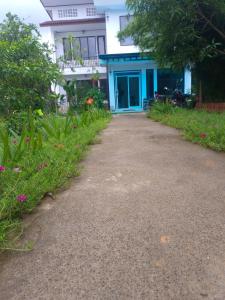 einen Weg zu einem Haus mit blauer Tür in der Unterkunft Dokchampa Hotel in Vang Vieng