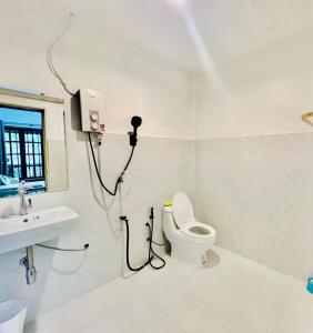 een witte badkamer met een toilet en een wastafel bij Utopia House Phangan in Mae Haad