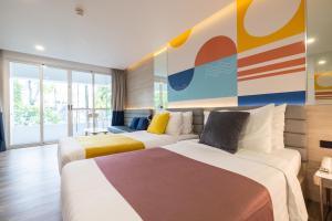 two beds in a hotel room with a mural at Boat Lagoon Yacht Marina Hotel in Ban Bang Khu