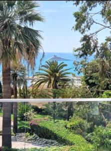 uitzicht vanaf het balkon van een resort met palmbomen bij Le Vallaya Suites & Spa in Menton