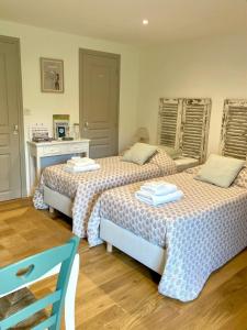 two beds sitting next to each other in a room at La Chambre du Saule in Trévières