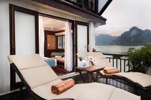 a balcony with chairs and a table with a view at Bhaya Halong Cruises in Ha Long