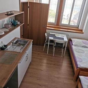 una pequeña cocina con fregadero, mesa y cama en VilaPavlov, en Pavlov