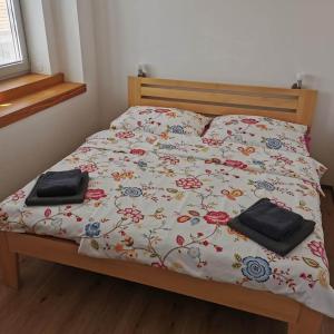 1 cama con colcha de flores y 2 almohadas en VilaPavlov, en Pavlov