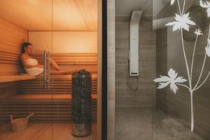 a woman is sitting in a sauna at Villa Matylda in Mariánské Lázně +54 photos