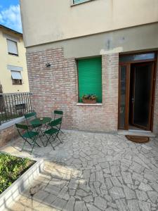 un patio con mesa y sillas frente a un edificio en La Casina di Cinzia en San Gimignano